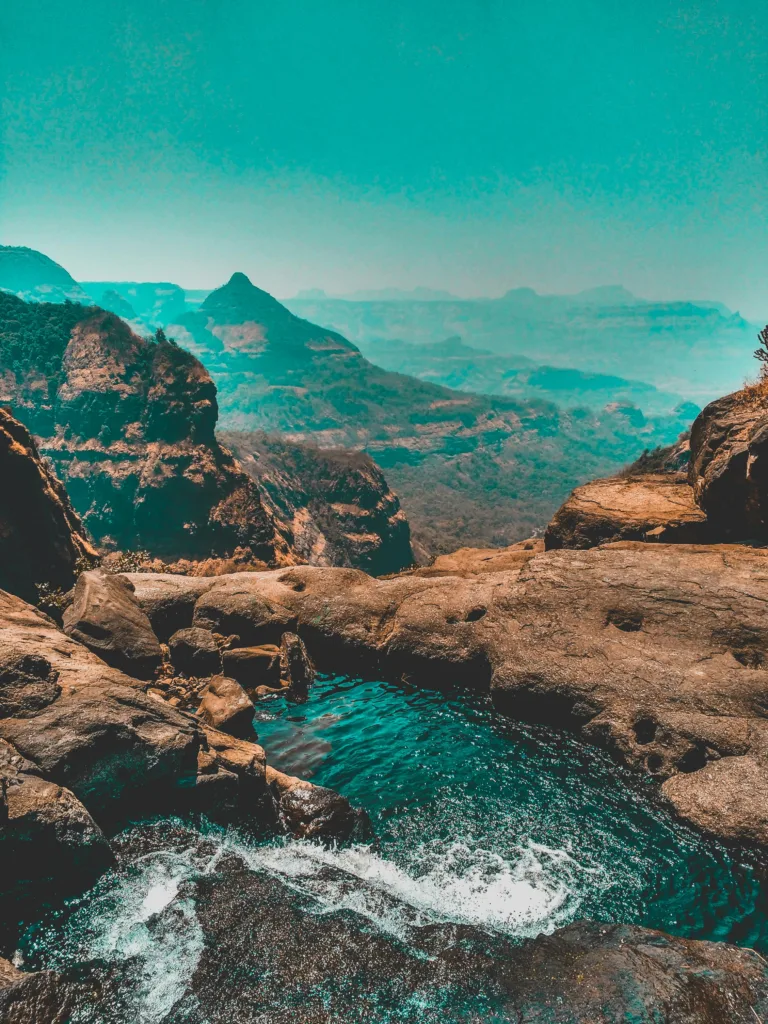 Stunning view of a mountain landscape with a scenic waterfall and vibrant sky.